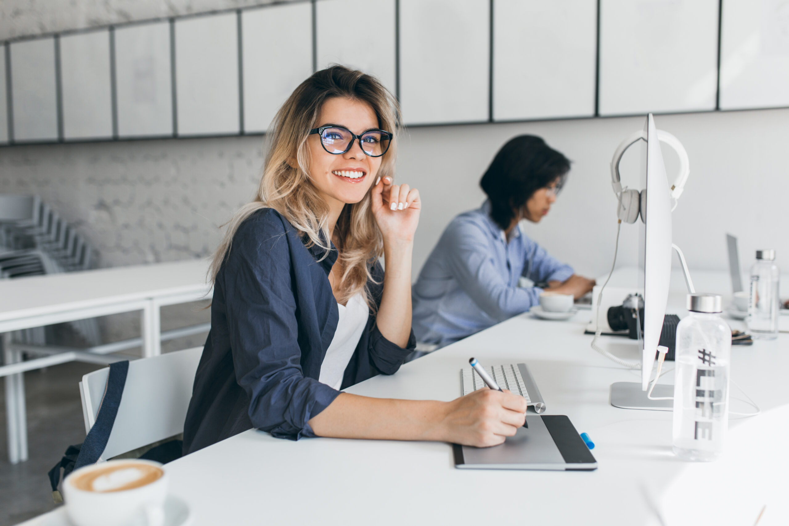 Female office worker carrying out administrative work for company. Indoor portrait of cute blonde student doing homework with university friend.
